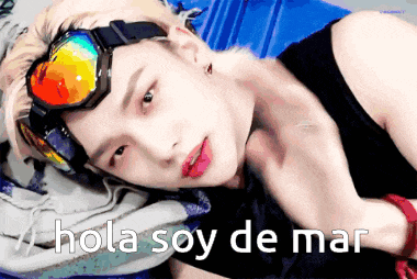 a young man wearing goggles is laying down with the words hola soy de mar written above him