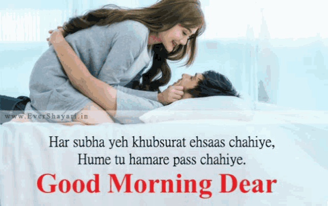a man and a woman laying on a bed with a good morning message