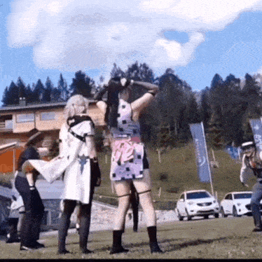 a group of people in costume are standing on a grassy field .