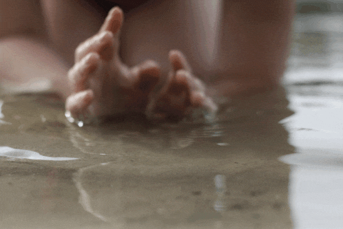 a person 's hands are visible in the water