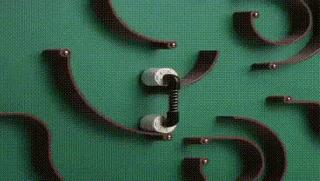 a close up of a marble run with a toothbrush on a green surface .