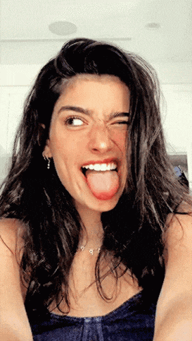 a woman sticking out her tongue and smiling