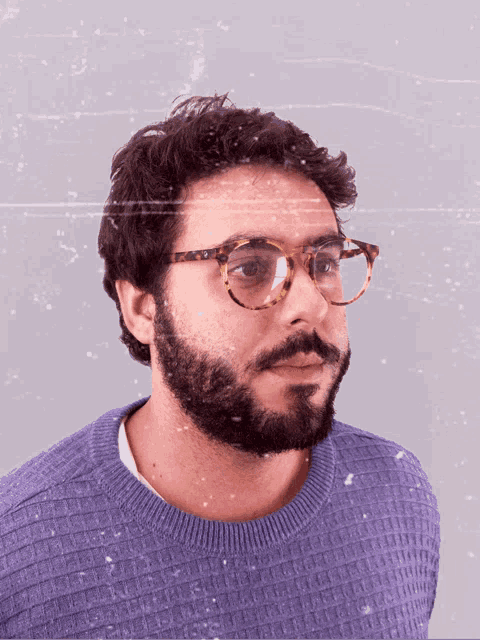 a man with a beard wearing glasses and a purple sweater