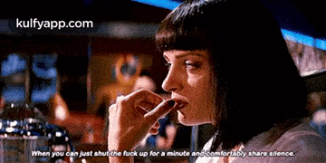 a woman is sitting at a table with her mouth open .