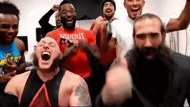 a man with a red shirt that says tapout is surrounded by other men