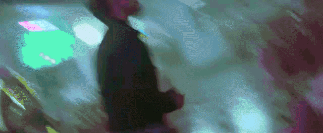 a blurry picture of a person standing in a room with a lot of lights .