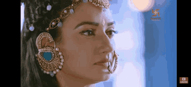 a close up of a woman wearing earrings and a necklace .
