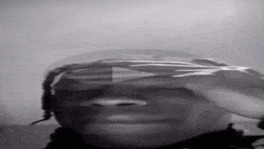 a black and white photo of a man covering his eyes with his hand
