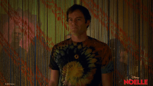 a man wearing a tie dye shirt with the word wow on it
