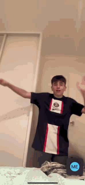 a boy in a nike shirt is dancing in a room