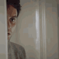 a close up of a man 's face behind a doorway