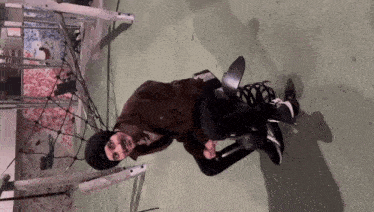 a man in a brown jacket is sitting on a swing set