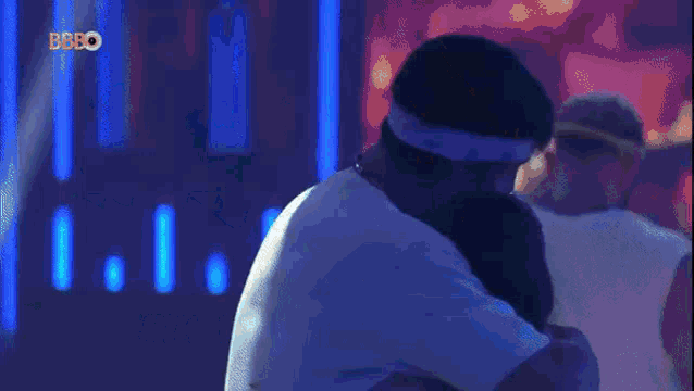 a man and woman are hugging each other in a dark room .