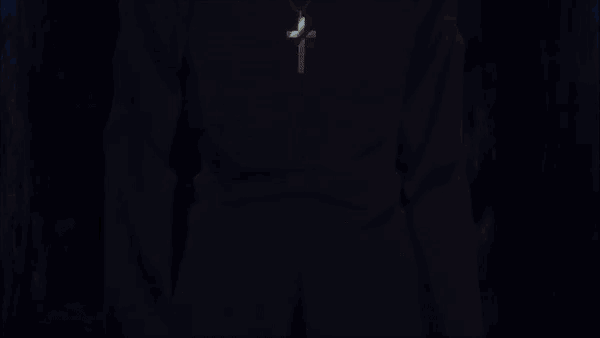 a man with white hair and a black turtleneck is holding something in his hand and pointing at it .