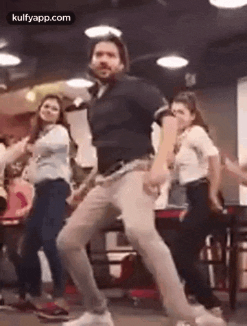 a man is dancing with a group of people in a room .