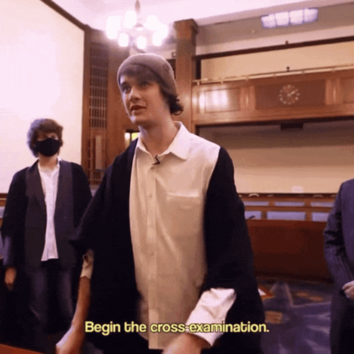a man standing in a room with the words begin the crossexamination