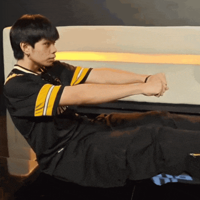 a man in a black and yellow jersey is sitting on a chair with his arms outstretched