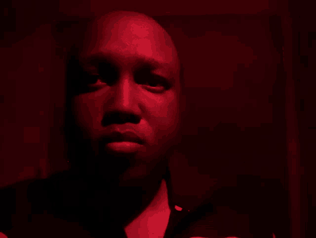 a man 's face is lit up with red light