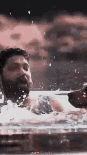 a man with a beard is swimming in the water