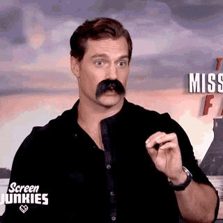 a man with a fake mustache is making a funny face .