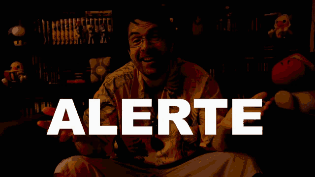 a man sitting in front of a sign that says " alerte "