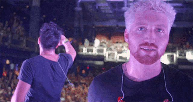 a man with a beard is standing in front of a crowd of people