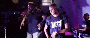 a man wearing a black shirt that says release is dancing