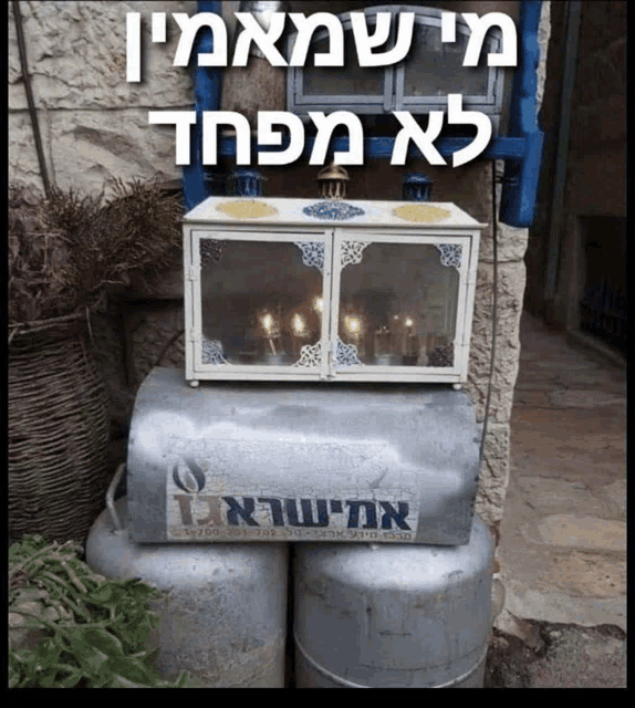 a box with candles in it sits on top of a stack of gas cylinders