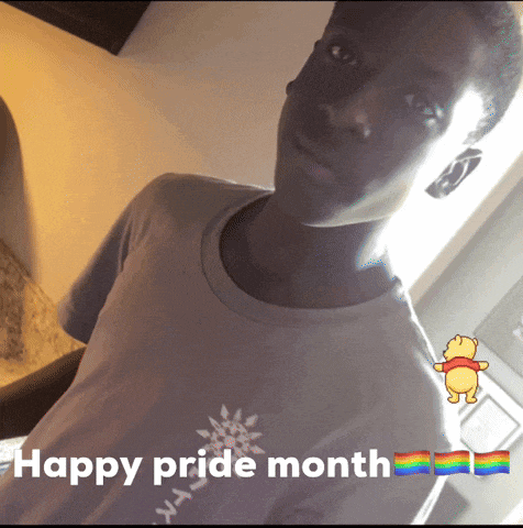a young man is wearing a t-shirt that says happy pride month