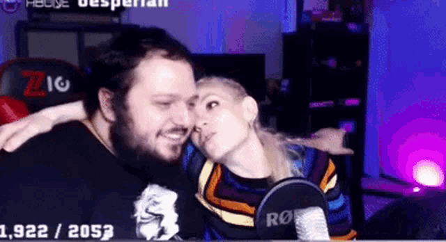 a man and a woman are sitting next to each other in front of a microphone .