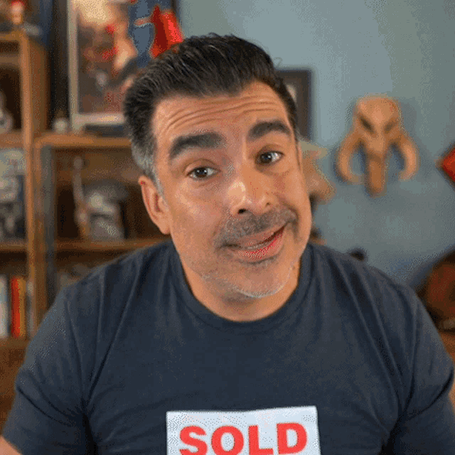 a man wearing a black shirt that says sold