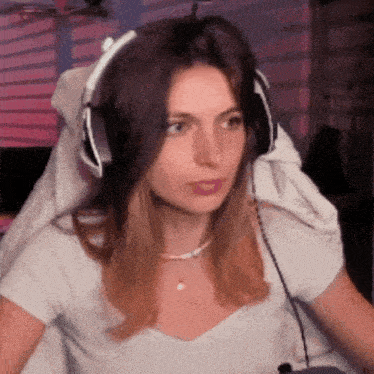 a woman wearing headphones looks at the camera