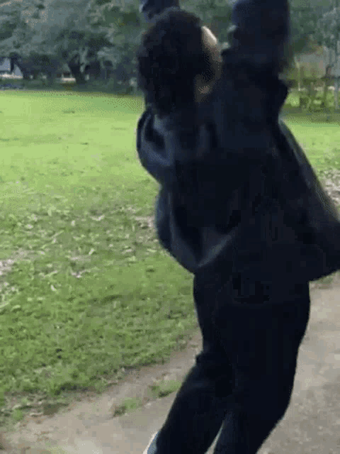 a man in a black jacket is throwing a frisbee in the air .