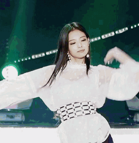 a woman is dancing on a stage in front of a green light .