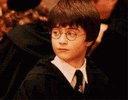 a young boy wearing glasses and a black robe and tie