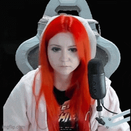 a woman with red hair is sitting in front of a microphone ..