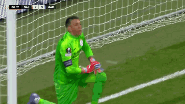 a soccer goalie is kneeling in front of a goal with the score of 2-0
