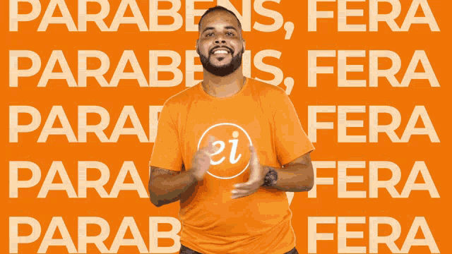 a man wearing an orange shirt with the word ei on it stands in front of a orange background
