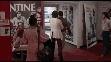 a group of people standing in front of a sign that says ' ntine '