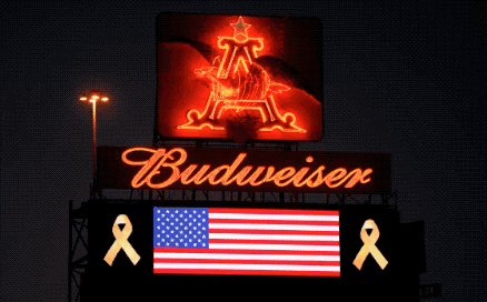 a budweiser billboard with an american flag and a yellow ribbon