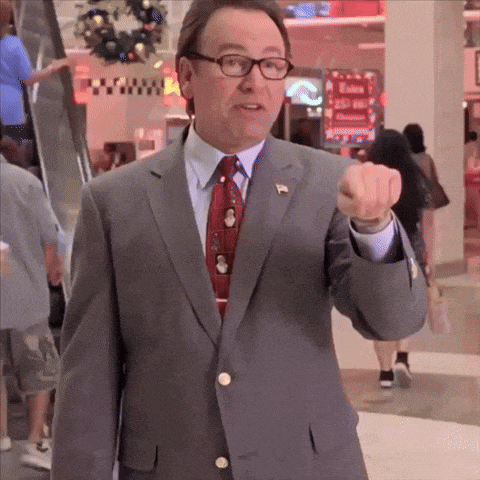 a man in a suit and tie is pointing