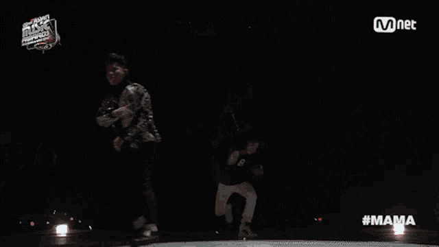 a man is doing a trick on a stage with a mnet logo in the background