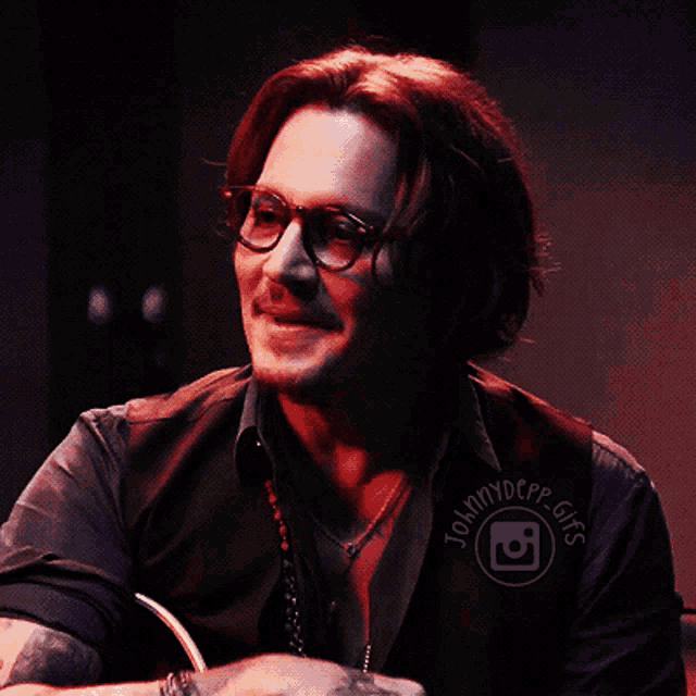 a man wearing glasses and a vest that says johnny depp gifs