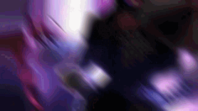 a blurry picture of a person in a dark room with purple lights
