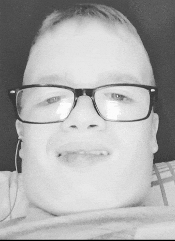 a young man wearing glasses is making a funny face in a black and white photo