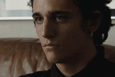 a close up of a young man 's face with a black shirt on