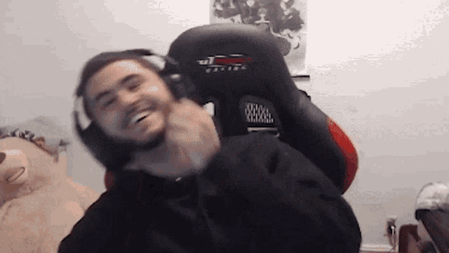 a man wearing headphones is sitting in a chair with the word gaming on it