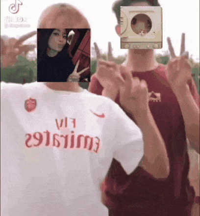 two men are standing next to each other and one has a picture of a girl on his face .