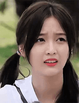 a close up of a woman making a funny face with her hair in pigtails .