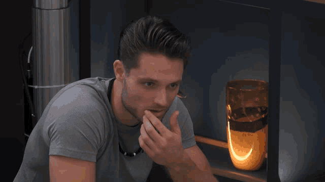 a man covering his mouth with his hand in front of a glass